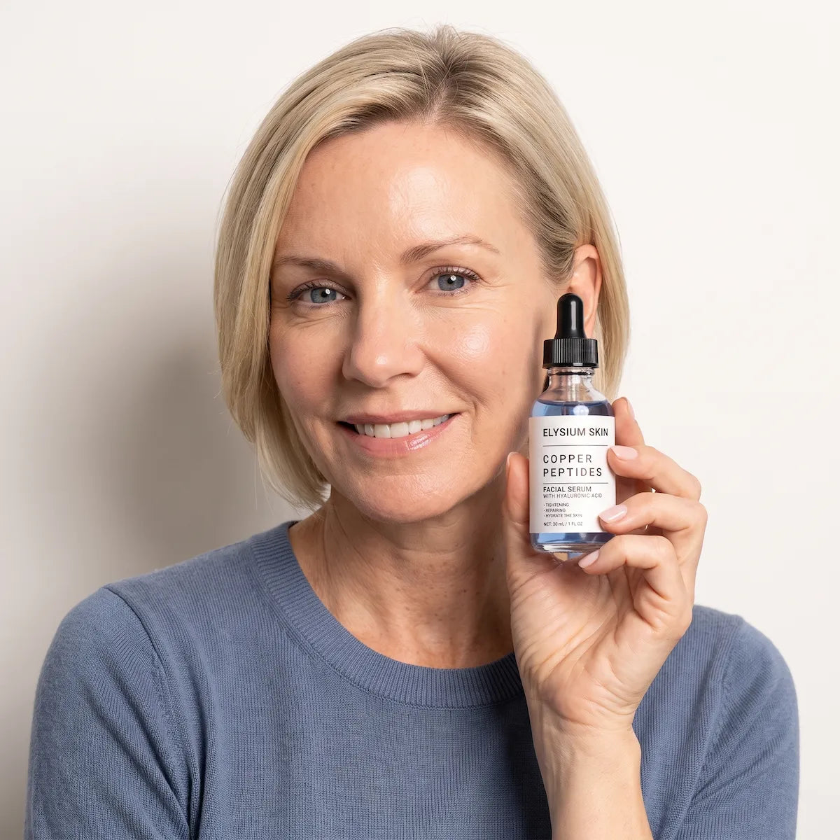 Woman holding Elysium Copper Peptide Renewal Serum